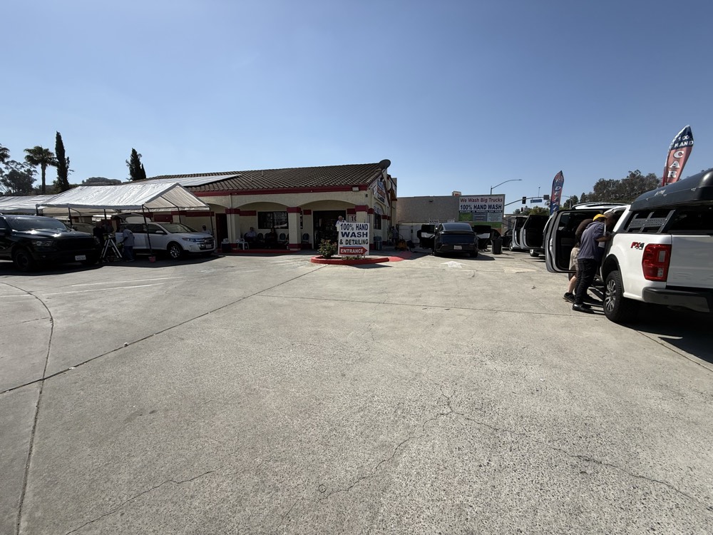 Covered wash bays at Magnolia Car Wash with vehicles being hand-washed